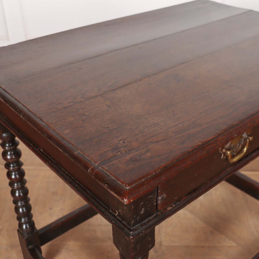 An 18th-century dark oak side table featuring a rectangular top, single drawer with brass handles, bobbin turned legs, and a box stretcher base. View VII