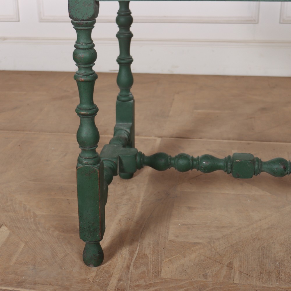 An 18th-century English lamp table featuring a dark green painted surface, single drawer with brass handles, and turned legs with lower stretchers. View III