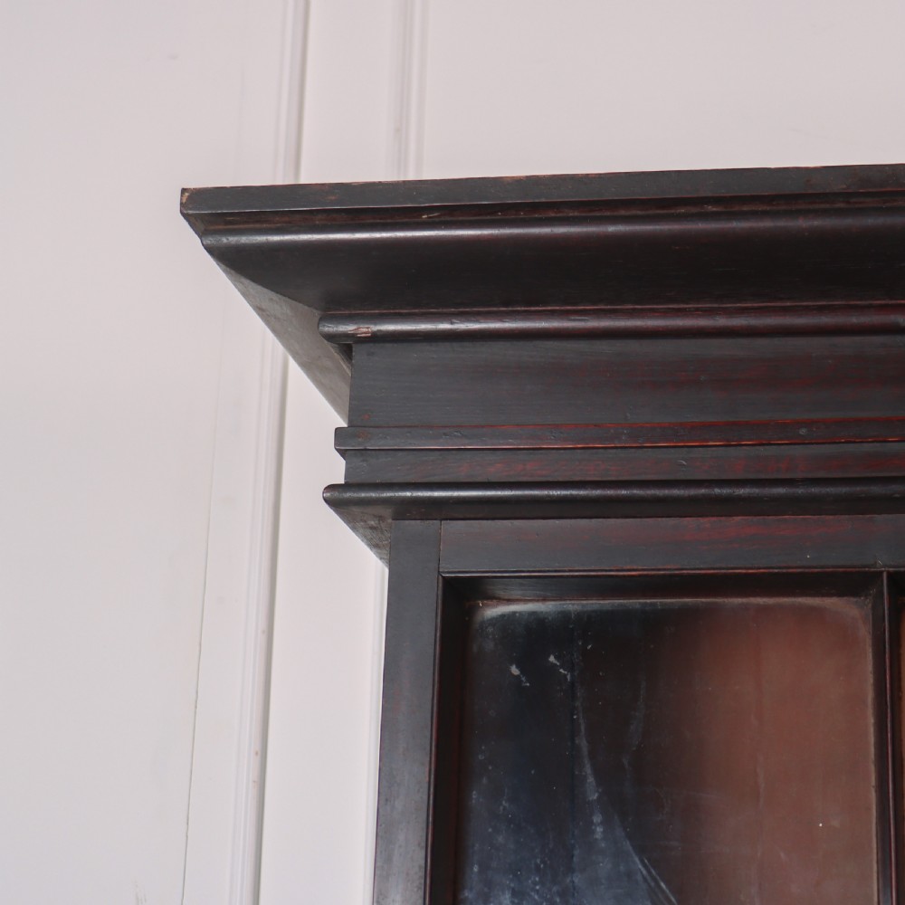 A dark brown antique oak glazed dresser featuring a upper display cabinet with three glass-front doors above a base with drawers and cupboard doors. View VIII