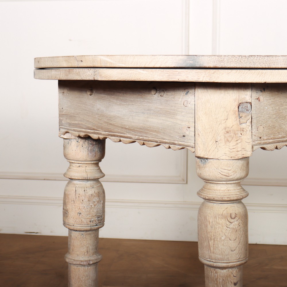 An 18th century Dutch demilune console table made from bleached oak, featuring three heavy turned legs, a scalloped apron, and a triangular low stretcher base. View III