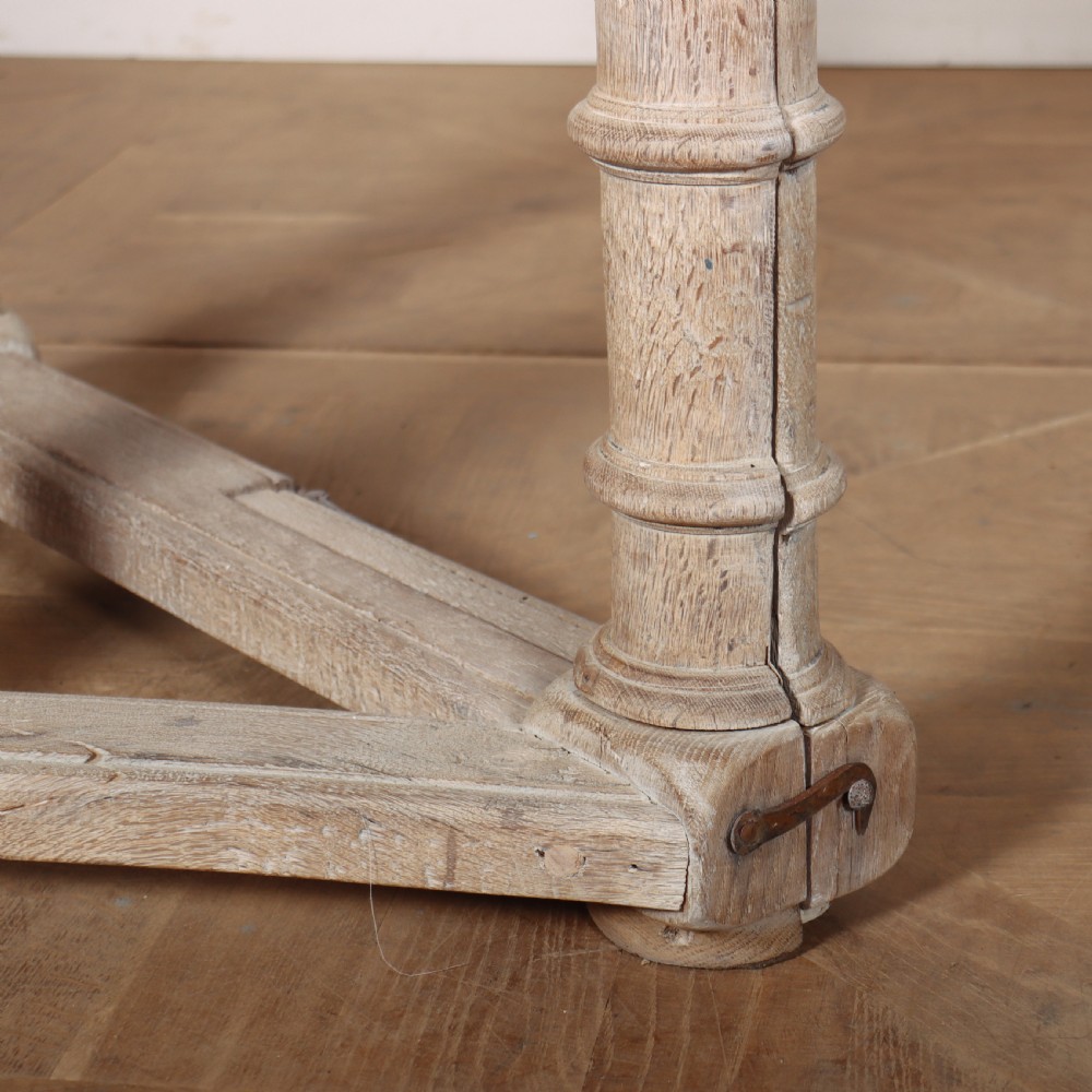 An 18th century Dutch demilune console table made from bleached oak, featuring three heavy turned legs, a scalloped apron, and a triangular low stretcher base. View IV
