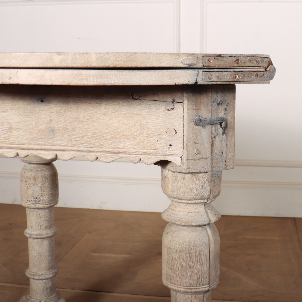 An 18th century Dutch demilune console table made from bleached oak, featuring three heavy turned legs, a scalloped apron, and a triangular low stretcher base. View V