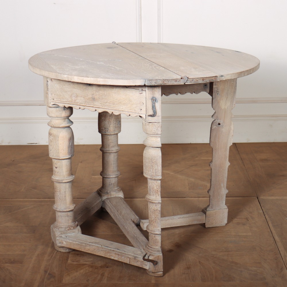 An 18th century Dutch demilune console table made from bleached oak, featuring three heavy turned legs, a scalloped apron, and a triangular low stretcher base. View VI