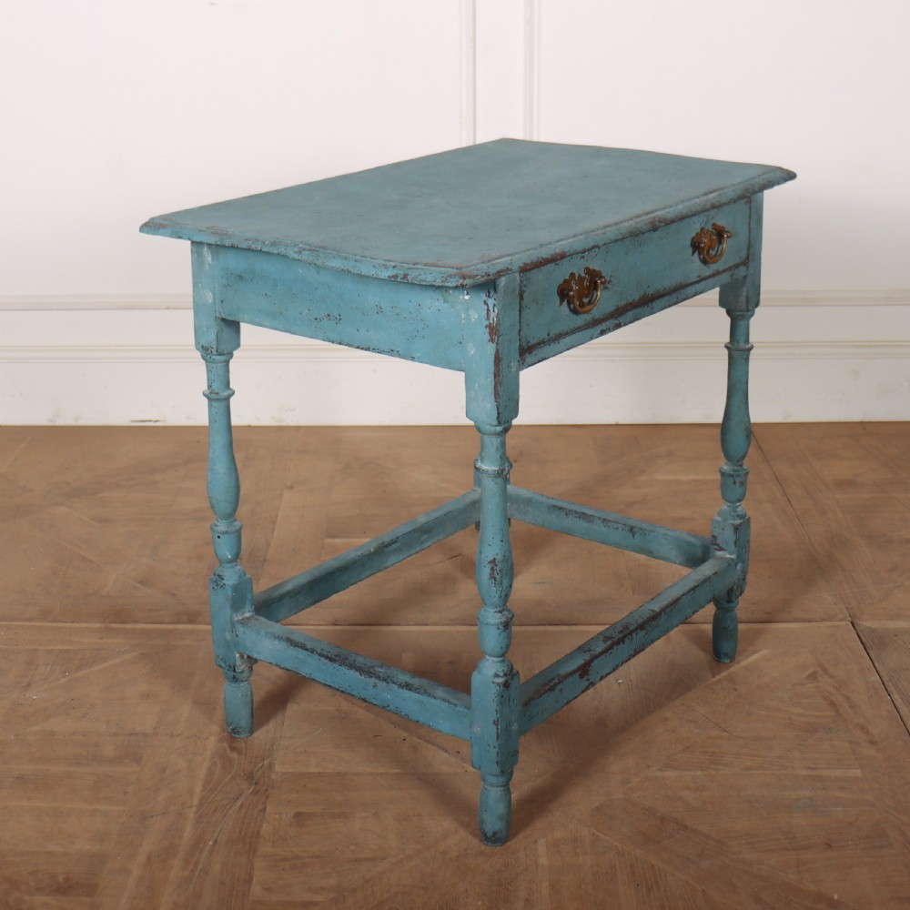 An 18th-century rectangular lamp table featuring a distressed blue painted finish, turned legs, a lower stretcher base, and a single drawer with brass handles. View V