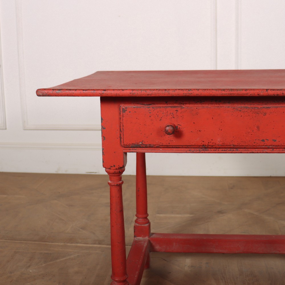 A red painted wooden lamp table featuring a single central drawer with wooden knobs, turned legs, and a lower stretcher base. View II