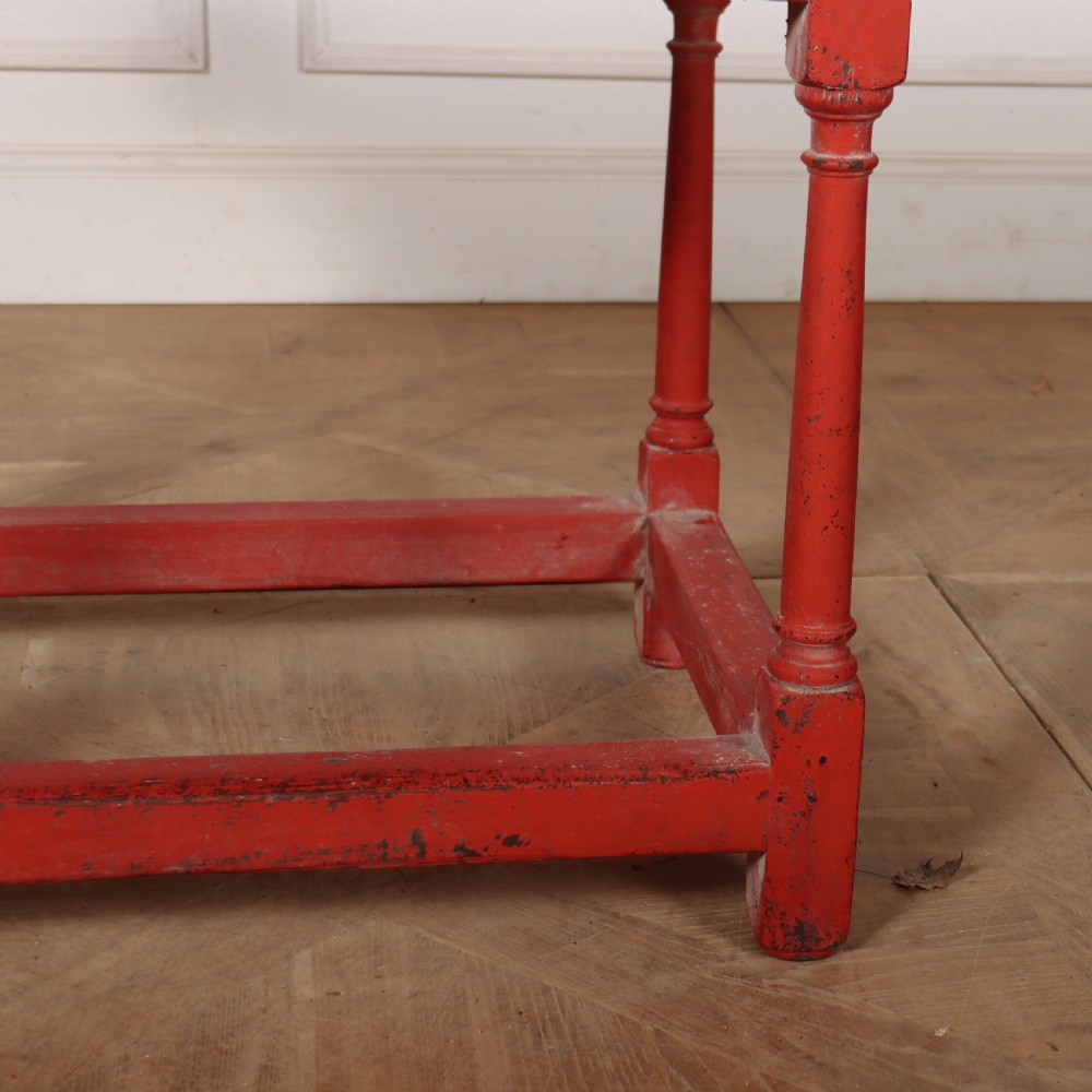 A red painted wooden lamp table featuring a single central drawer with wooden knobs, turned legs, and a lower stretcher base. View III