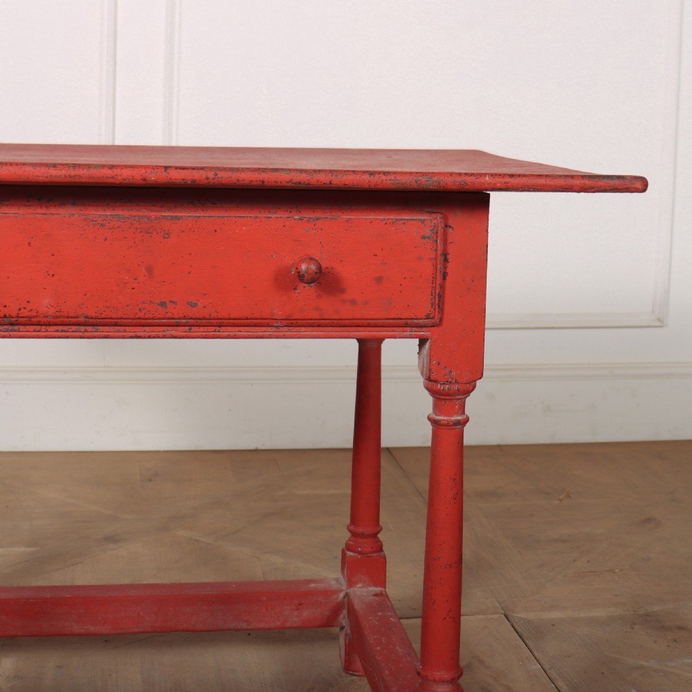 A red painted wooden lamp table featuring a single central drawer with wooden knobs, turned legs, and a lower stretcher base. View IV