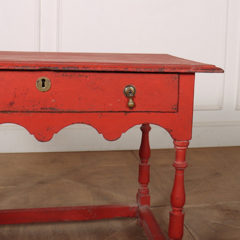 An 18th-century red painted timber side table featuring a single drawer with brass drop handles, a scalloped apron, turned legs, and a full box stretcher. View III