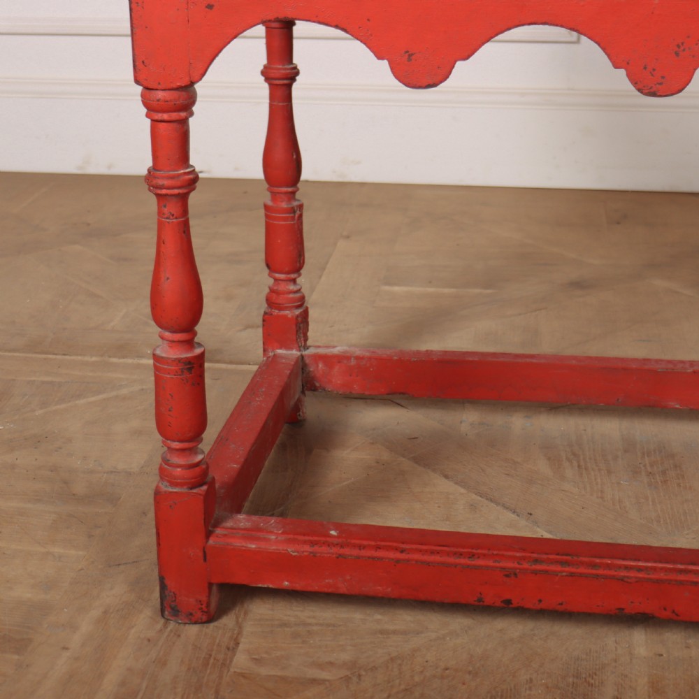 An 18th-century red painted timber side table featuring a single drawer with brass drop handles, a scalloped apron, turned legs, and a full box stretcher. View IV