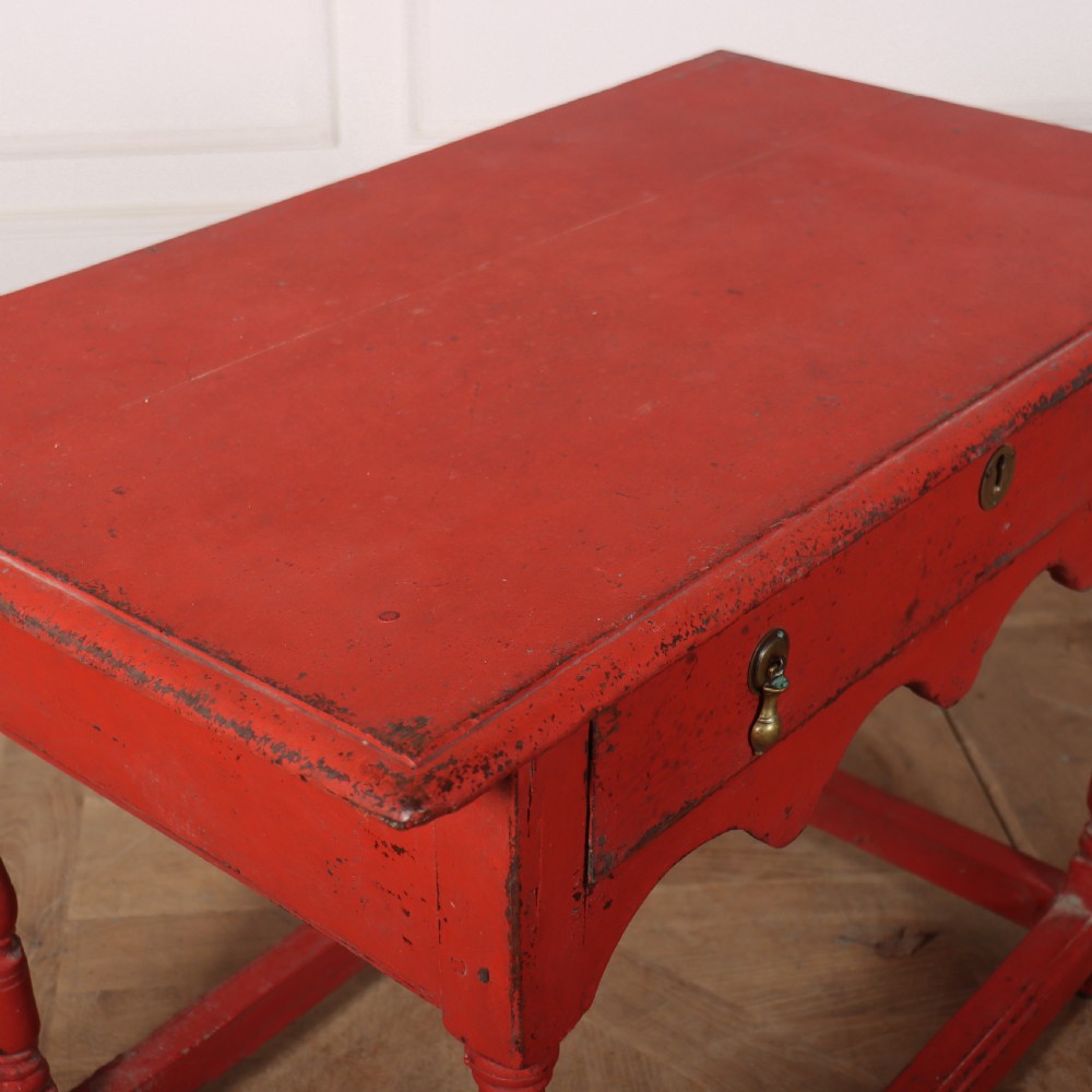 An 18th-century red painted timber side table featuring a single drawer with brass drop handles, a scalloped apron, turned legs, and a full box stretcher. View VII