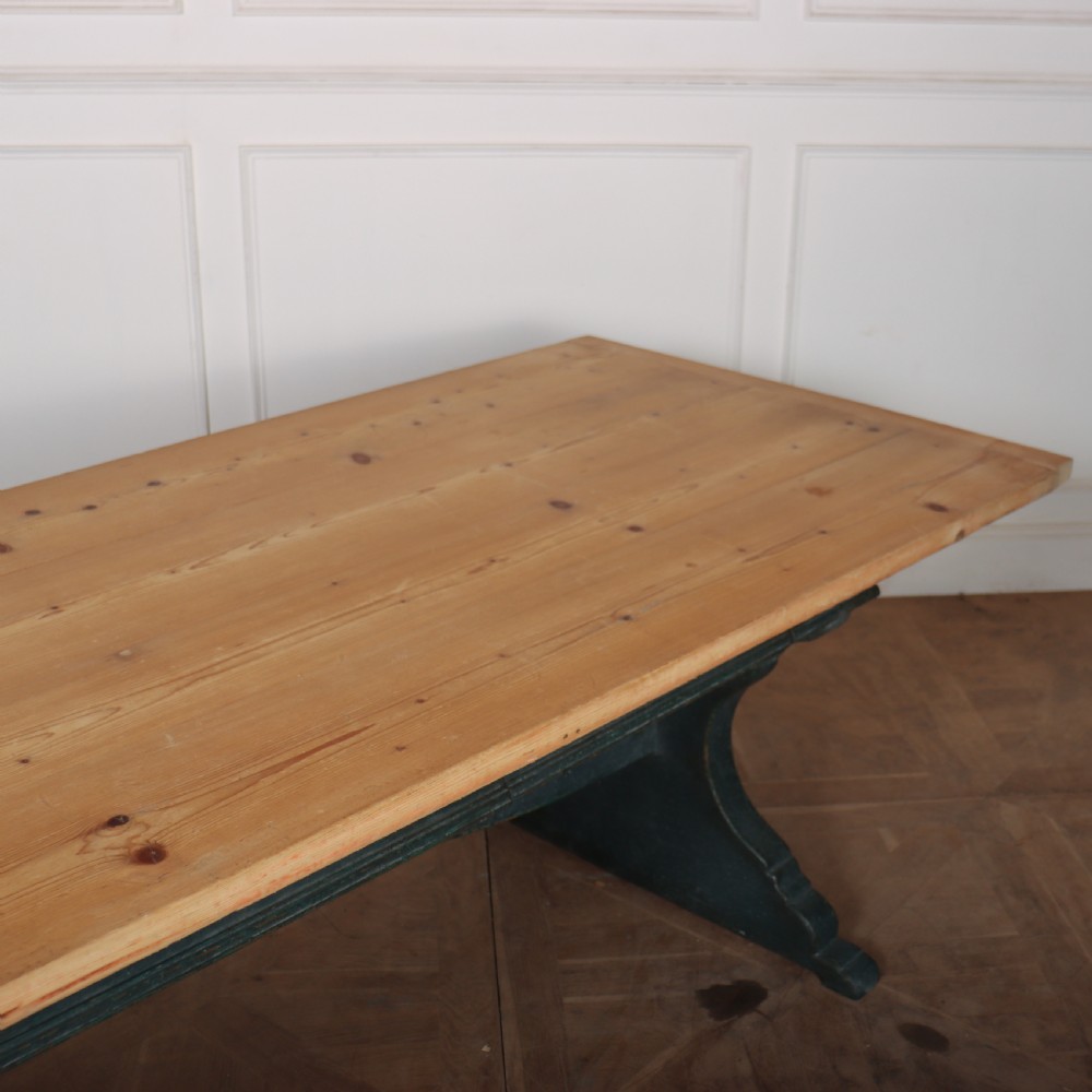An Italian trestle table featuring a scrubbed natural pine top supported by a dark teal painted timber base with shaped legs and a central stretcher. View VI
