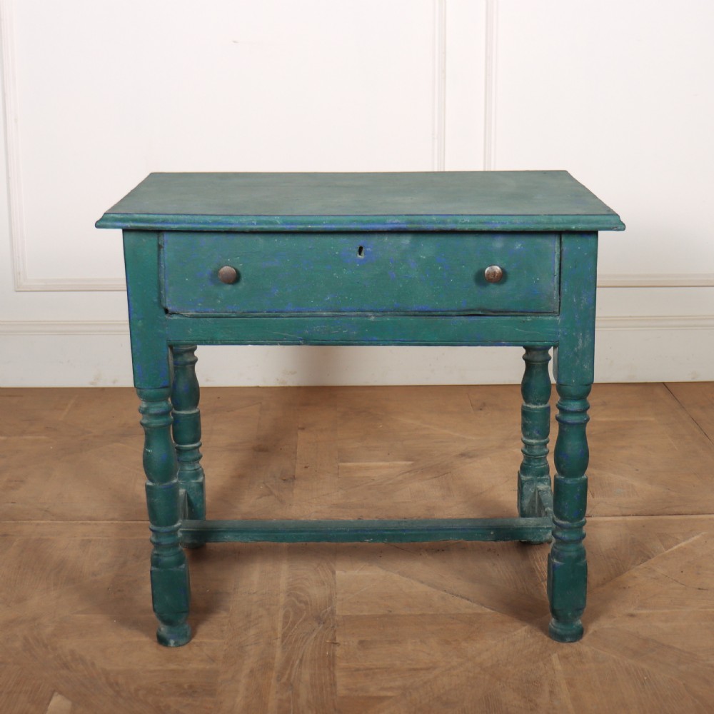 An English side table featuring a weathered teal green painted finish, a single drawer with two round knobs, turned legs, and lower stretchers.