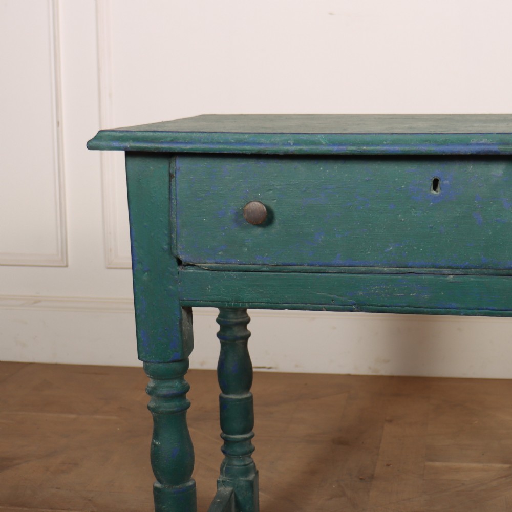 An English side table featuring a weathered teal green painted finish, a single drawer with two round knobs, turned legs, and lower stretchers. View III