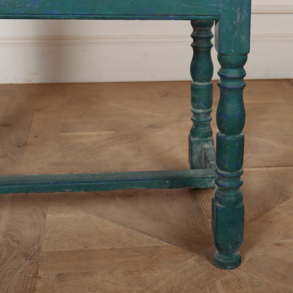 An English side table featuring a weathered teal green painted finish, a single drawer with two round knobs, turned legs, and lower stretchers. View VI