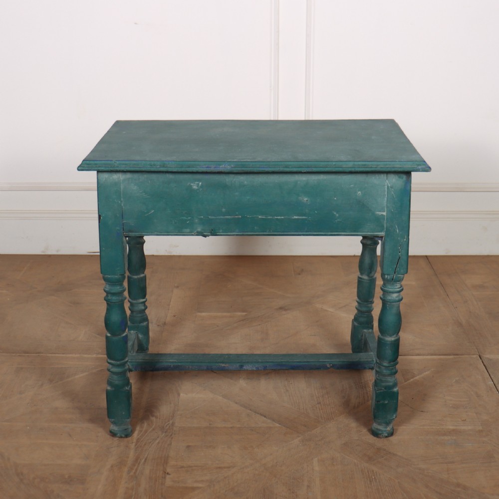 An English side table featuring a weathered teal green painted finish, a single drawer with two round knobs, turned legs, and lower stretchers. View VII