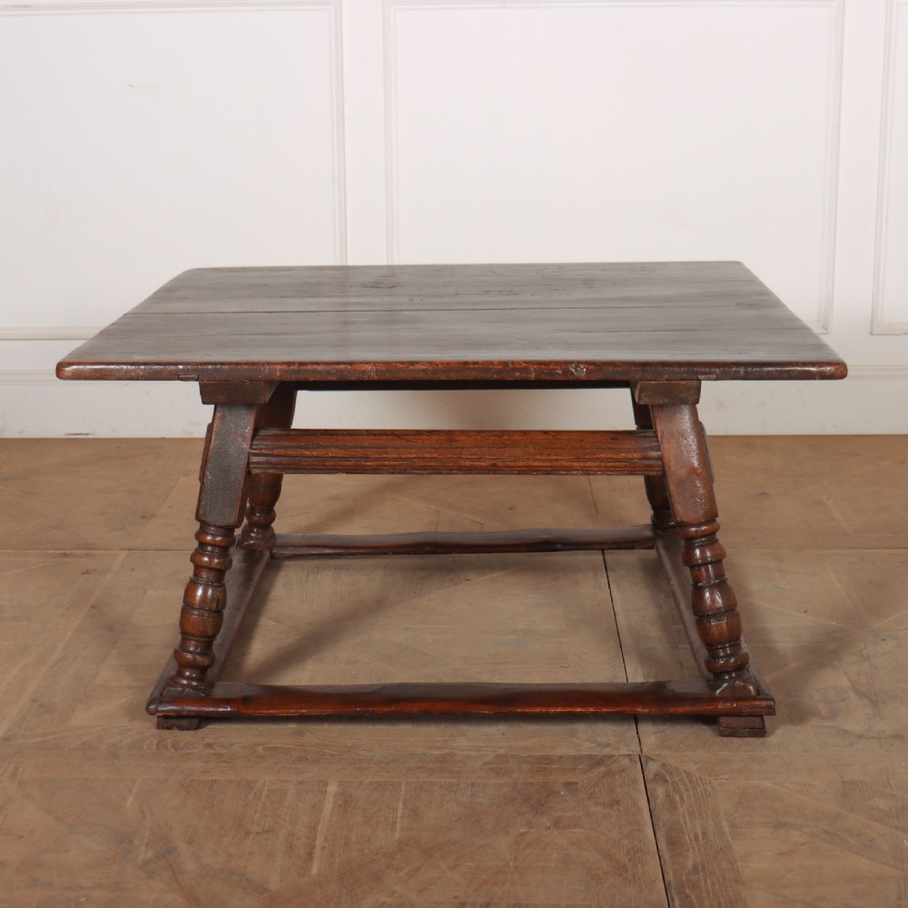 An 18th-century Austrian low table crafted from dark wood with splayed turned legs and a sturdy perimeter stretcher base.