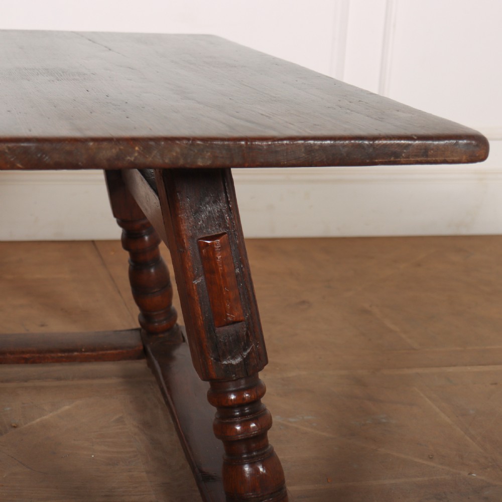 An 18th-century Austrian low table crafted from dark wood with splayed turned legs and a sturdy perimeter stretcher base. View V