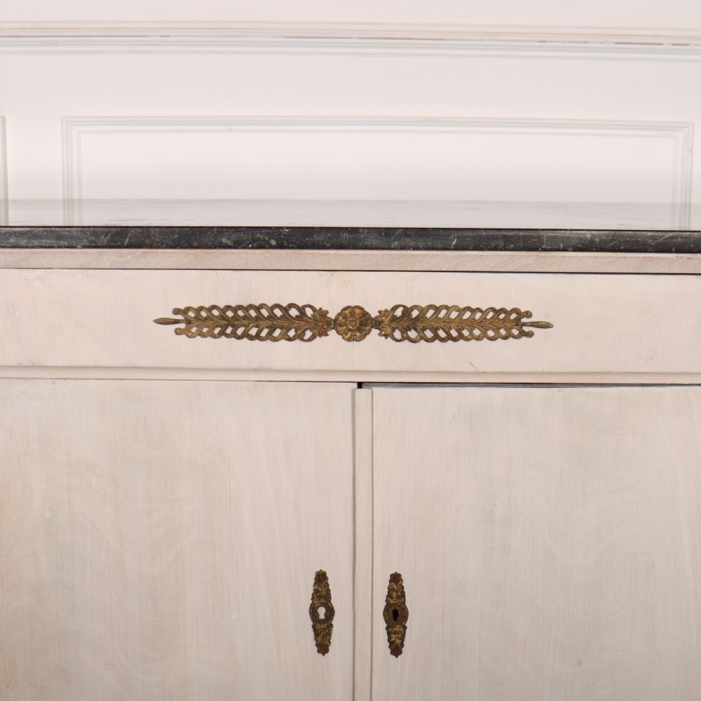 A long French Empire style painted wooden enfilade with four doors, columnar legs, brass escutcheons, and a dark marble top. View IV