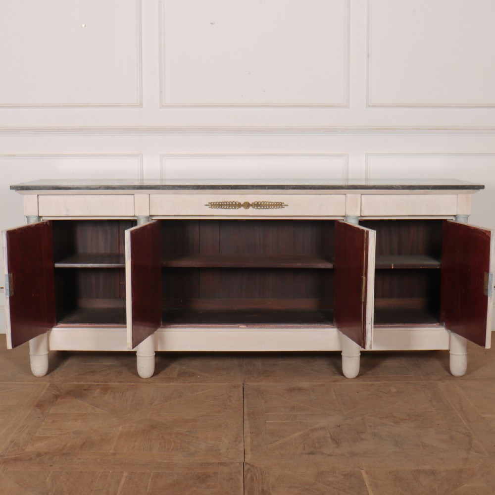 A long French Empire style painted wooden enfilade with four doors, columnar legs, brass escutcheons, and a dark marble top. View VI