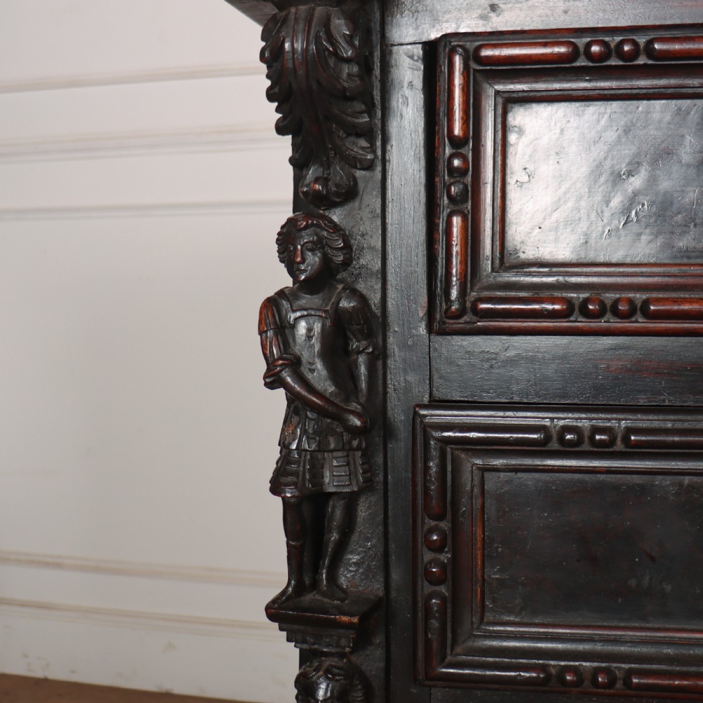 An 18th-century dark walnut Italian commode featuring carved mask pulls, caryatid pilasters, and carved claw feet. View II