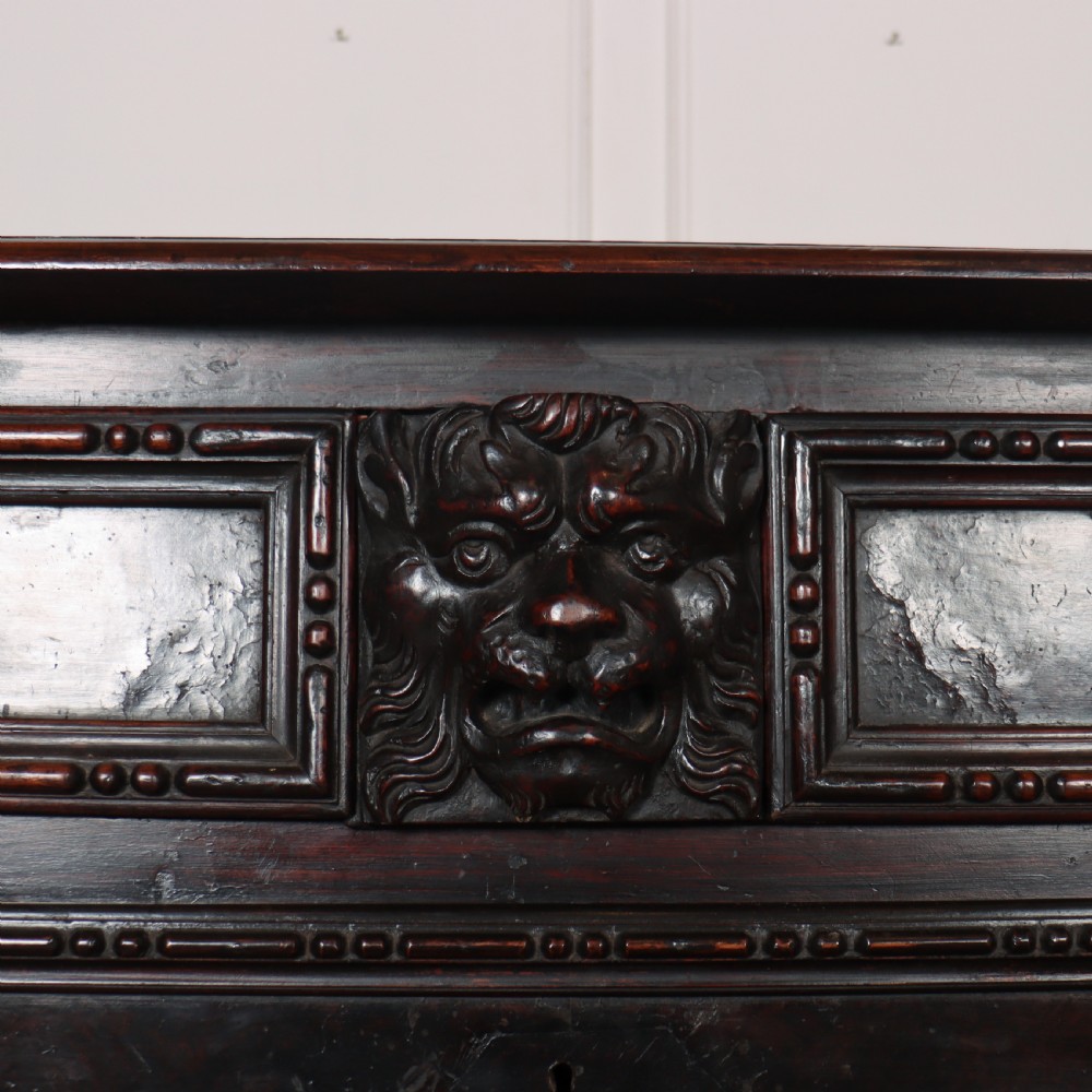 An 18th-century dark walnut Italian commode featuring carved mask pulls, caryatid pilasters, and carved claw feet. View VI