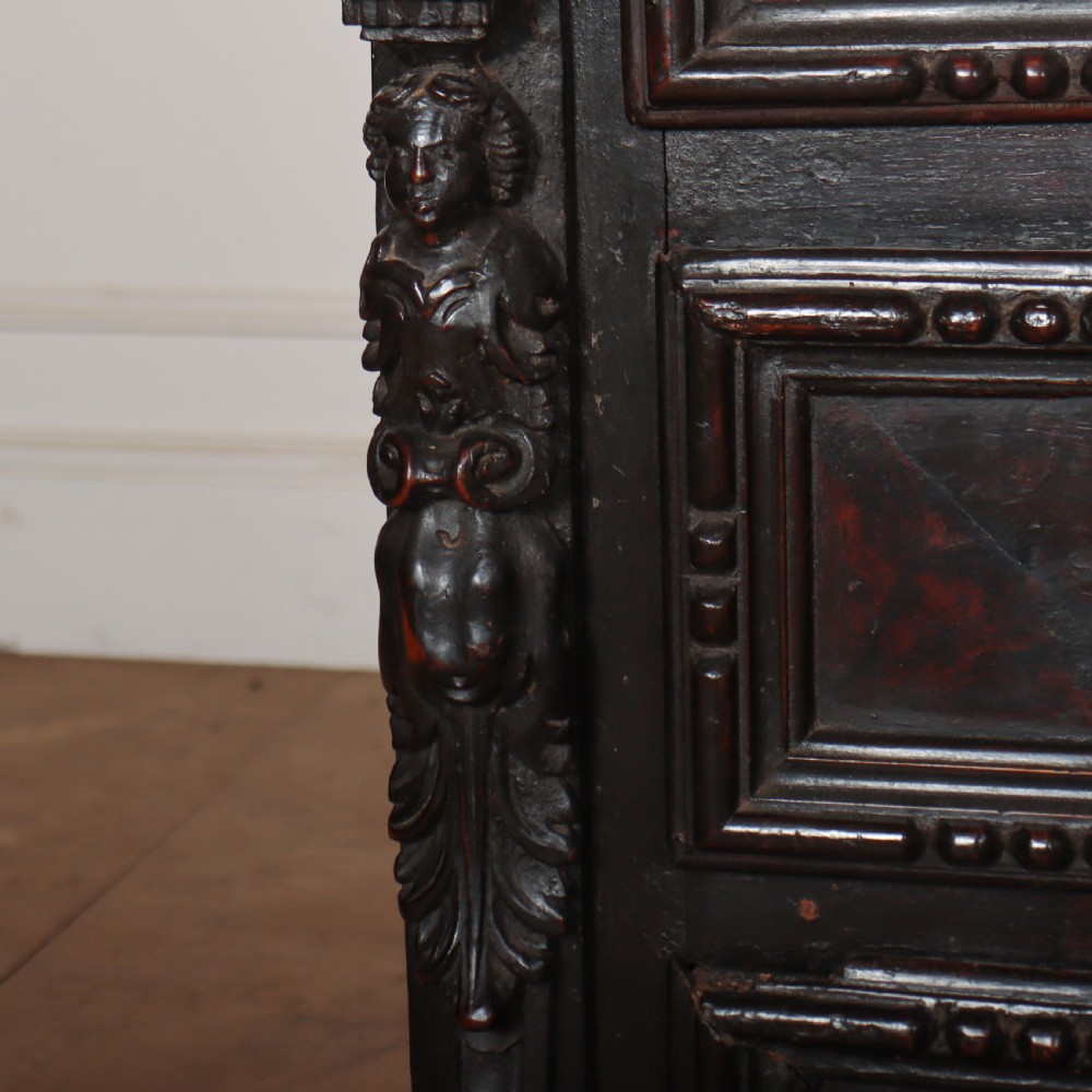 An 18th-century dark walnut Italian commode featuring carved mask pulls, caryatid pilasters, and carved claw feet. View VII
