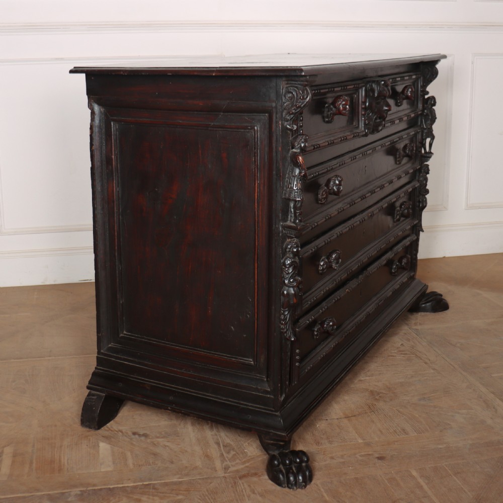 An 18th-century dark walnut Italian commode featuring carved mask pulls, caryatid pilasters, and carved claw feet. View X