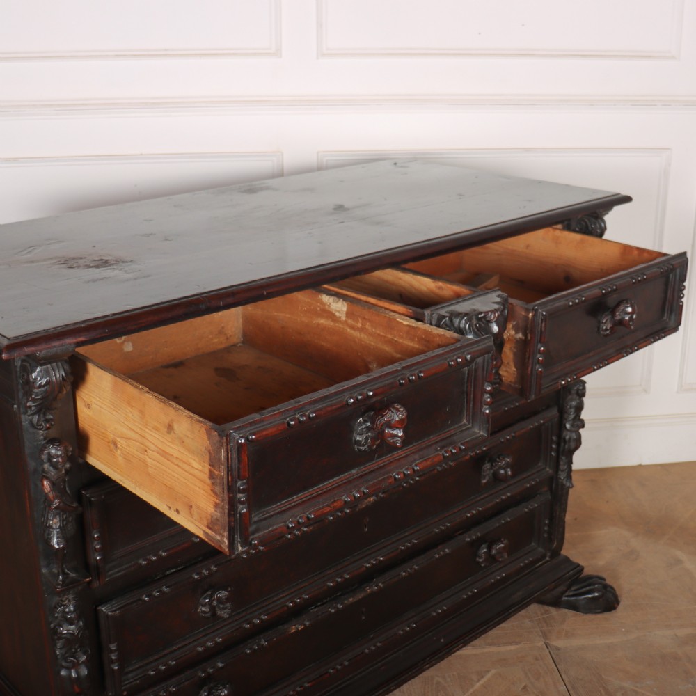 An 18th-century dark walnut Italian commode featuring carved mask pulls, caryatid pilasters, and carved claw feet. View XI