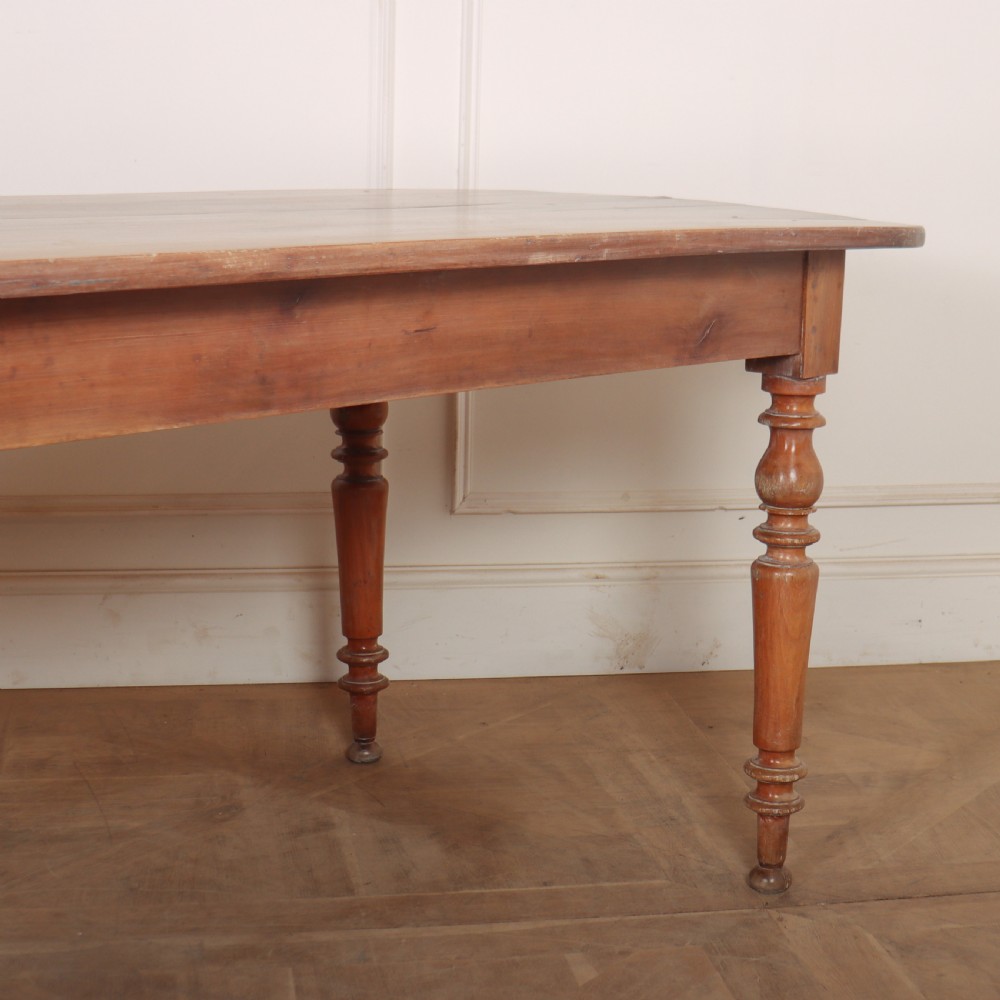A long wooden French farmhouse dining table featuring rounded D-shaped ends and turned legs. View III