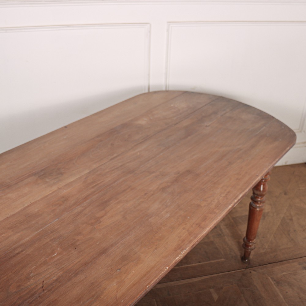 A long wooden French farmhouse dining table featuring rounded D-shaped ends and turned legs. View V