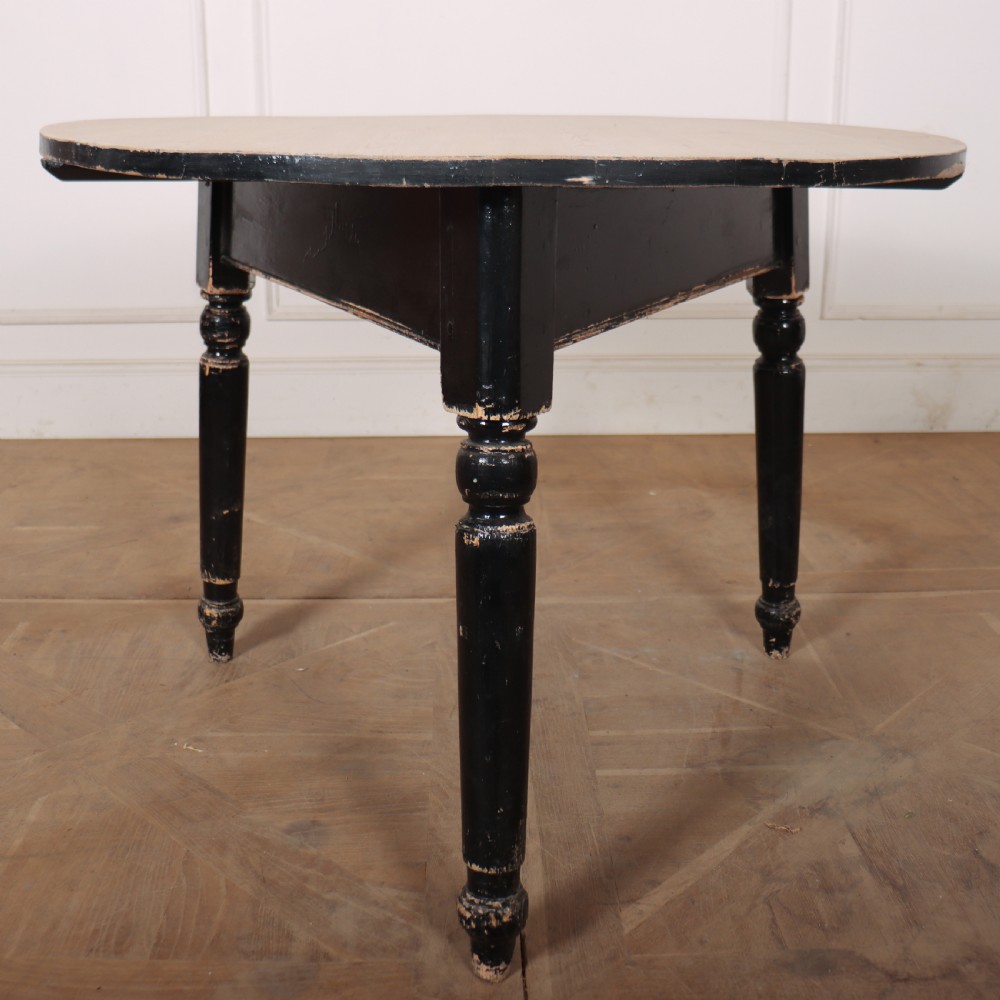 A Welsh pine cricket table featuring a circular scrubbed timber top supported by three turned legs in a distressed black painted finish. View II