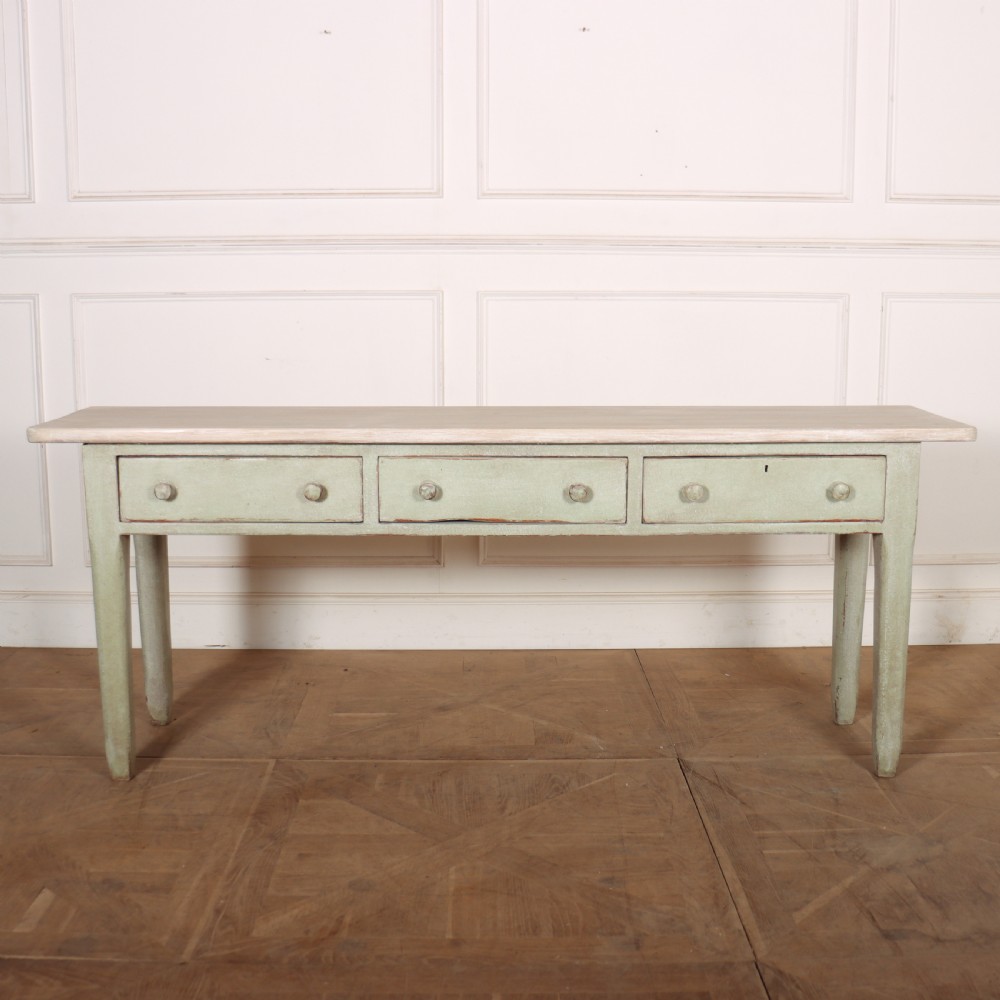 A long narrow wooden console table featuring a pale green painted base, three drawers with wooden turned knobs, and a natural light wood top.