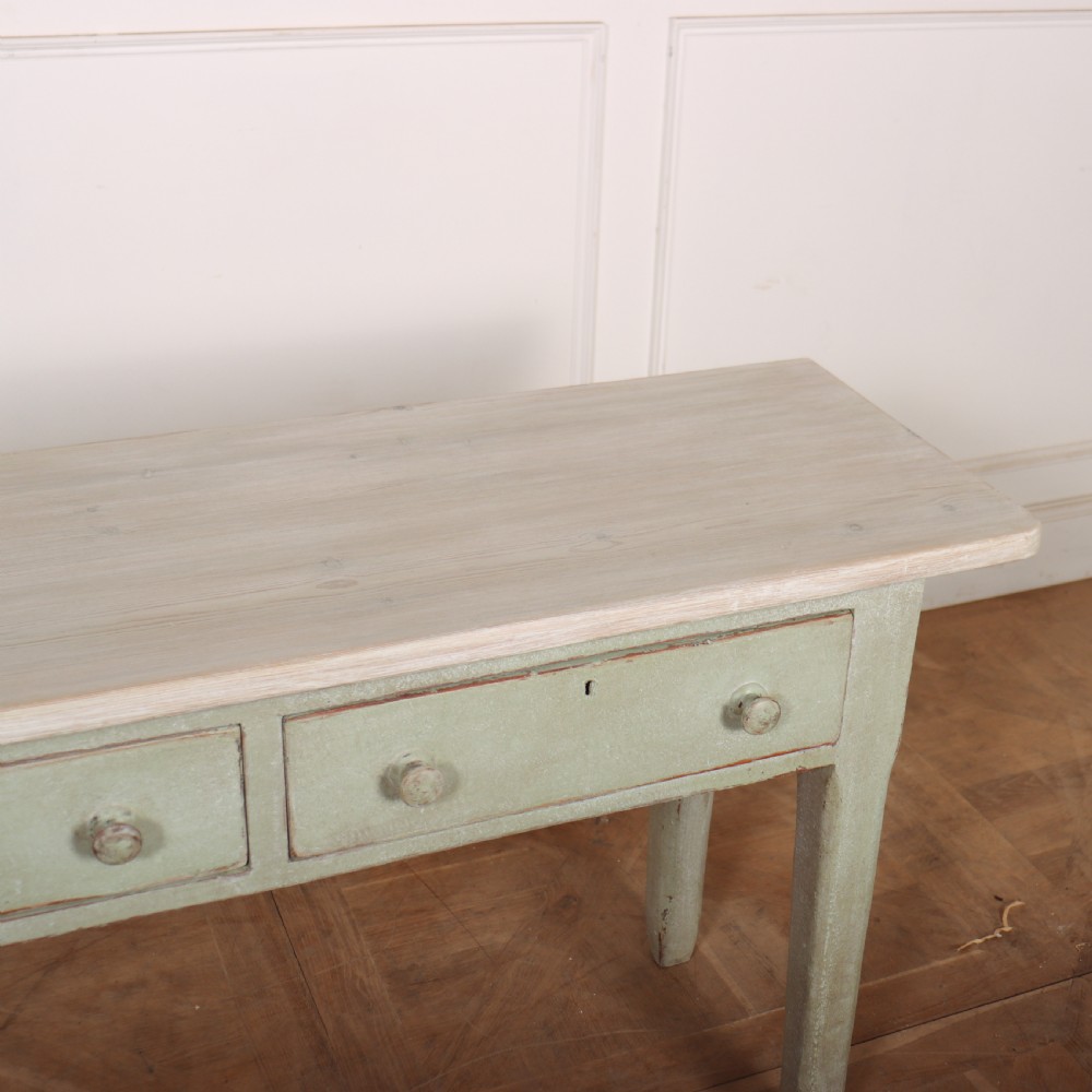 A long narrow wooden console table featuring a pale green painted base, three drawers with wooden turned knobs, and a natural light wood top. View V