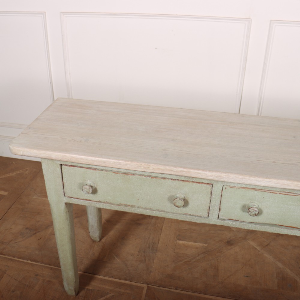 A long narrow wooden console table featuring a pale green painted base, three drawers with wooden turned knobs, and a natural light wood top. View VI