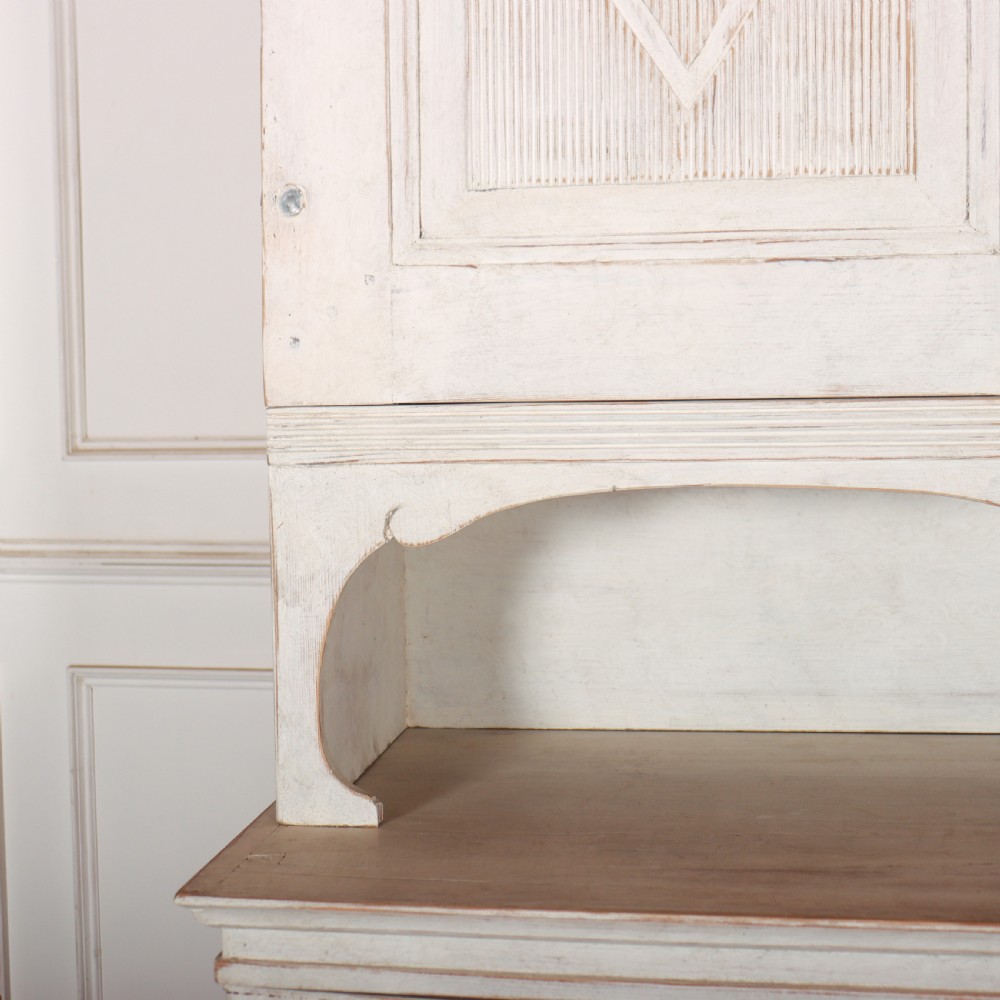 A two-tier Swedish painted wooden cabinet featuring distressed off-white paint, carved diamond geometric panels on four doors, and central brass escutcheons. View III
