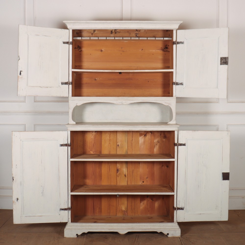 A two-tier Swedish painted wooden cabinet featuring distressed off-white paint, carved diamond geometric panels on four doors, and central brass escutcheons. View IV