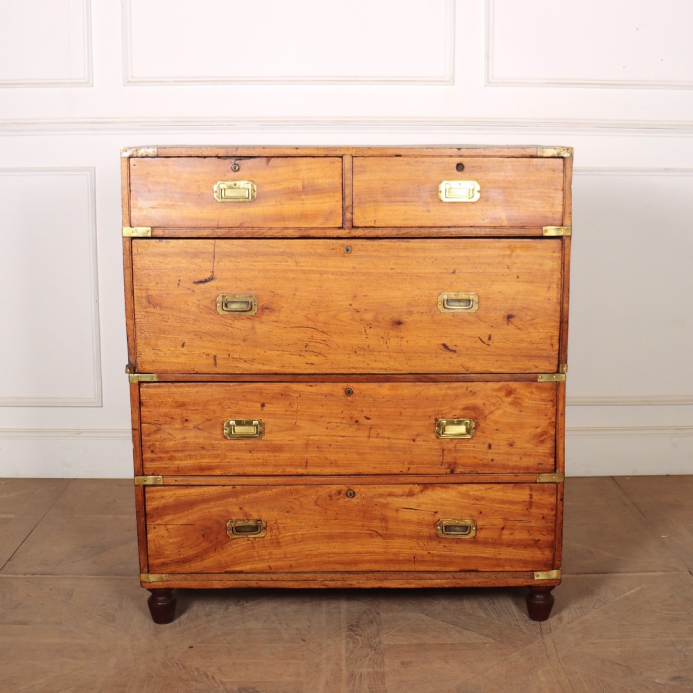 A nineteenth-century two-part military campaign chest of drawers in warm brown timber featuring flush brass handles and corner straps.
