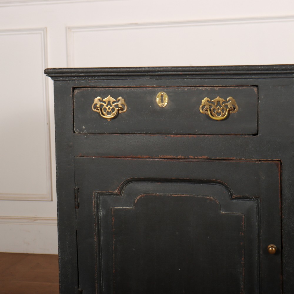 An 18th-century painted wooden dresser base in dark grey featuring three upper drawers with brass swan-neck handles over three cupboard doors with raised panels. View II