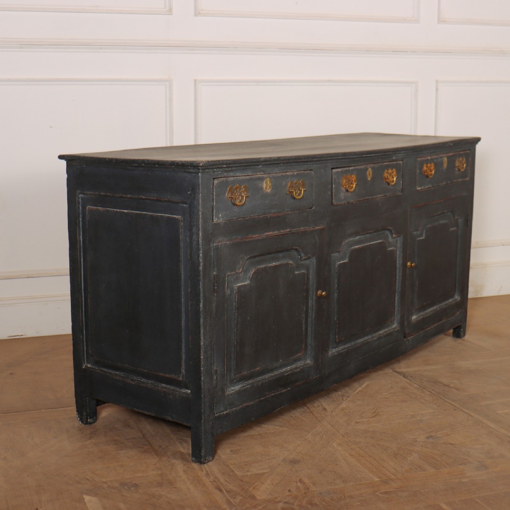 An 18th-century painted wooden dresser base in dark grey featuring three upper drawers with brass swan-neck handles over three cupboard doors with raised panels. View V