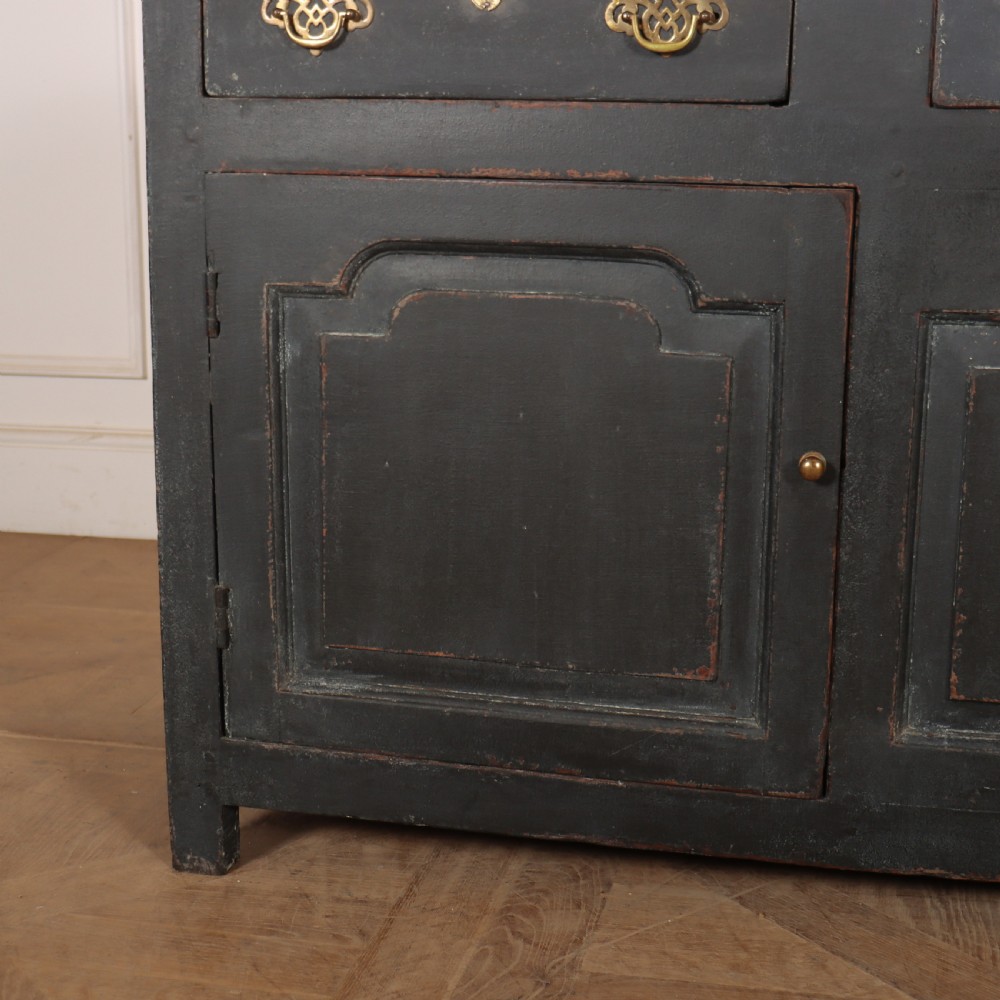 An 18th-century painted wooden dresser base in dark grey featuring three upper drawers with brass swan-neck handles over three cupboard doors with raised panels. View VII
