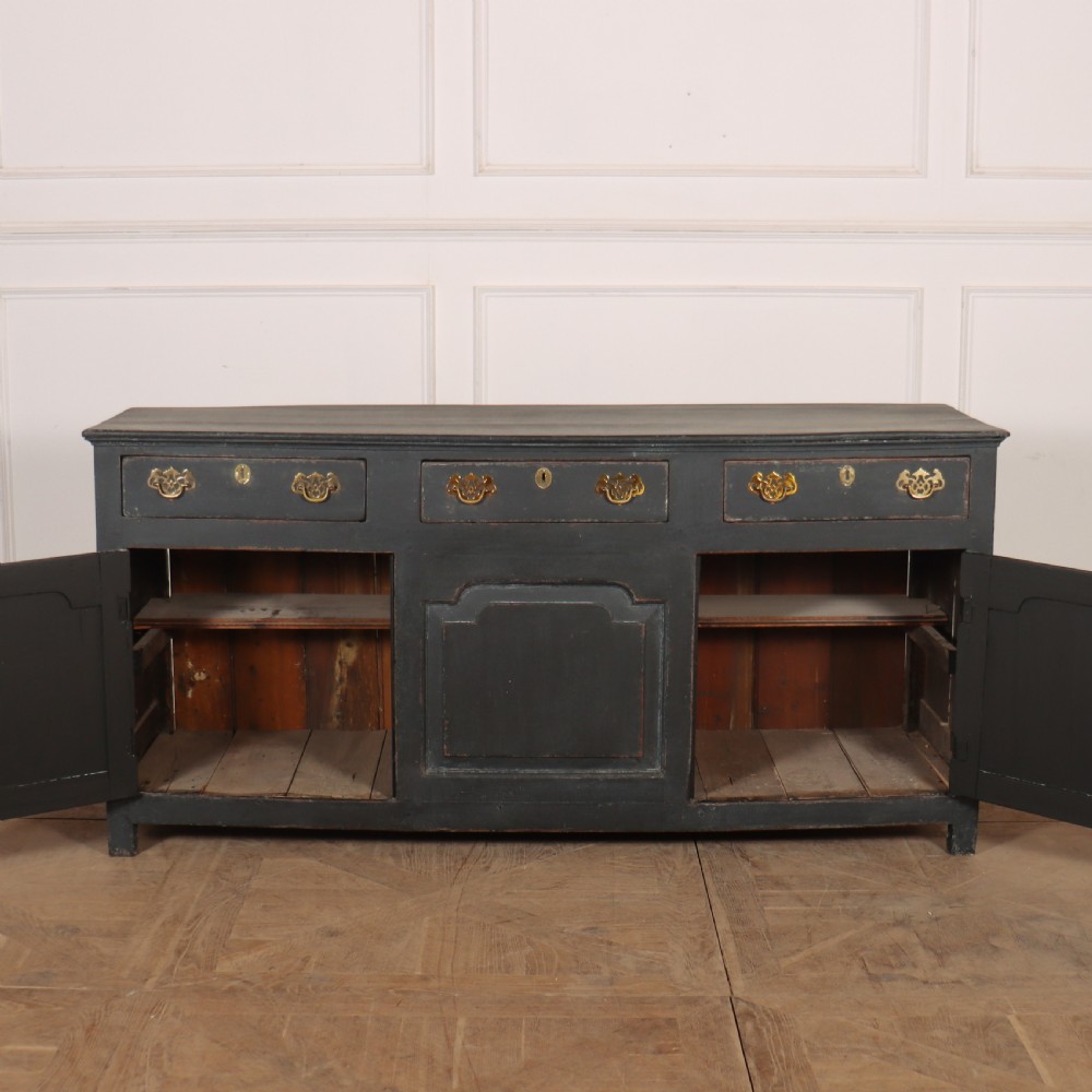 An 18th-century painted wooden dresser base in dark grey featuring three upper drawers with brass swan-neck handles over three cupboard doors with raised panels. View IX
