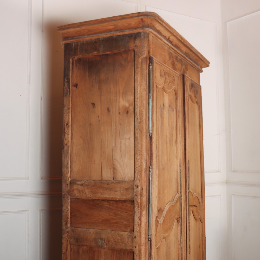 An 18th-century French provincial bleached oak armoire featuring two carved panel doors, long vertical iron hinges, and a moulded cornice. View IX