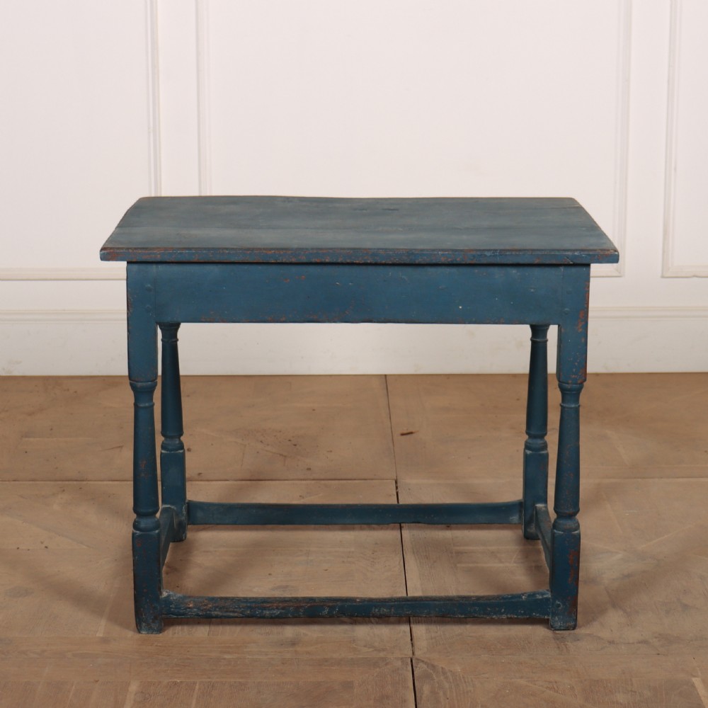 An 18th-century rectangular wooden side table featuring turned legs, a low box stretcher, and a distressed blue painted finish.