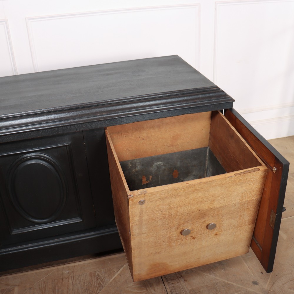 A low black painted wooden credenza featuring three panelled doors with oval mouldings and resting on carved paw feet. View V