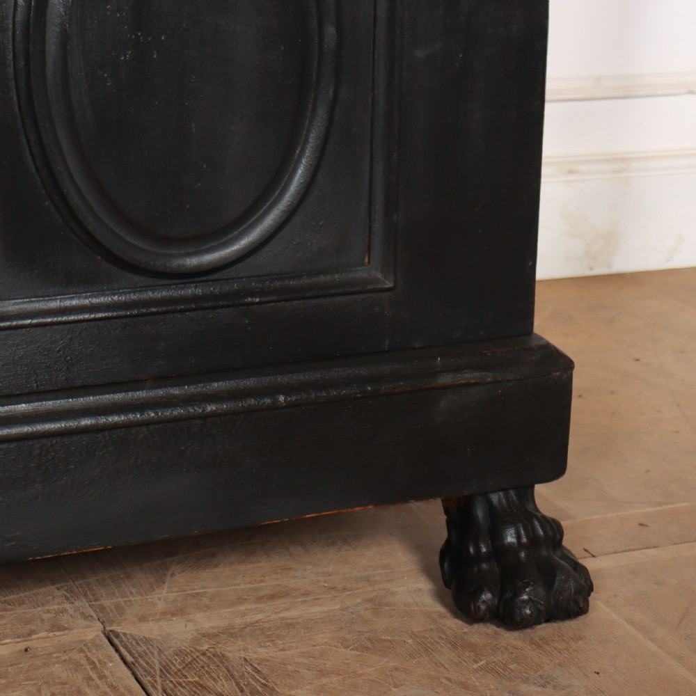 A low black painted wooden credenza featuring three panelled doors with oval mouldings and resting on carved paw feet. View VI