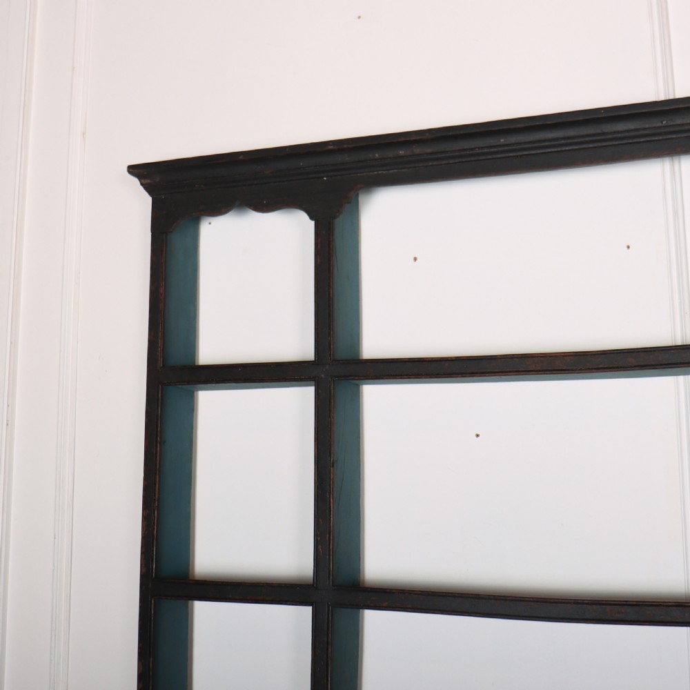 An 18th-century dark painted wooden kitchen dresser base featuring four drawers with brass handles beneath an open wall-mounted plate rack. View V