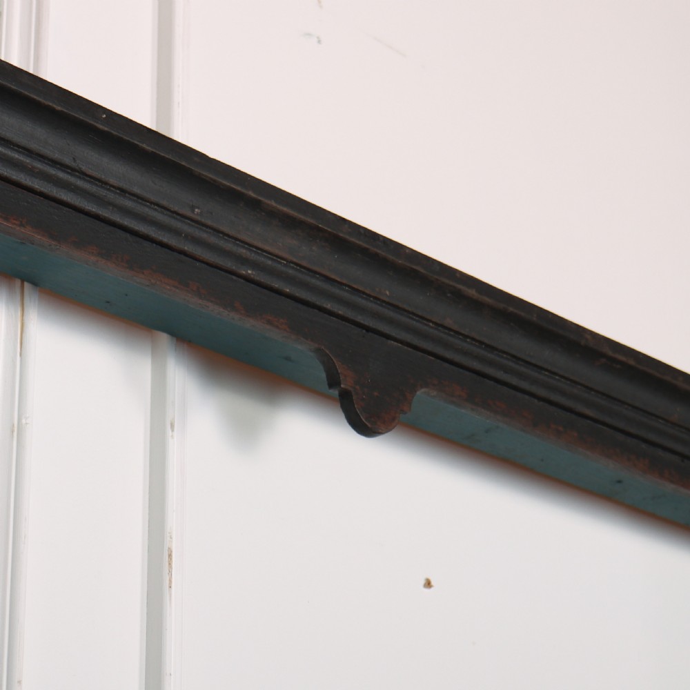 An 18th-century dark painted wooden kitchen dresser base featuring four drawers with brass handles beneath an open wall-mounted plate rack. View IX