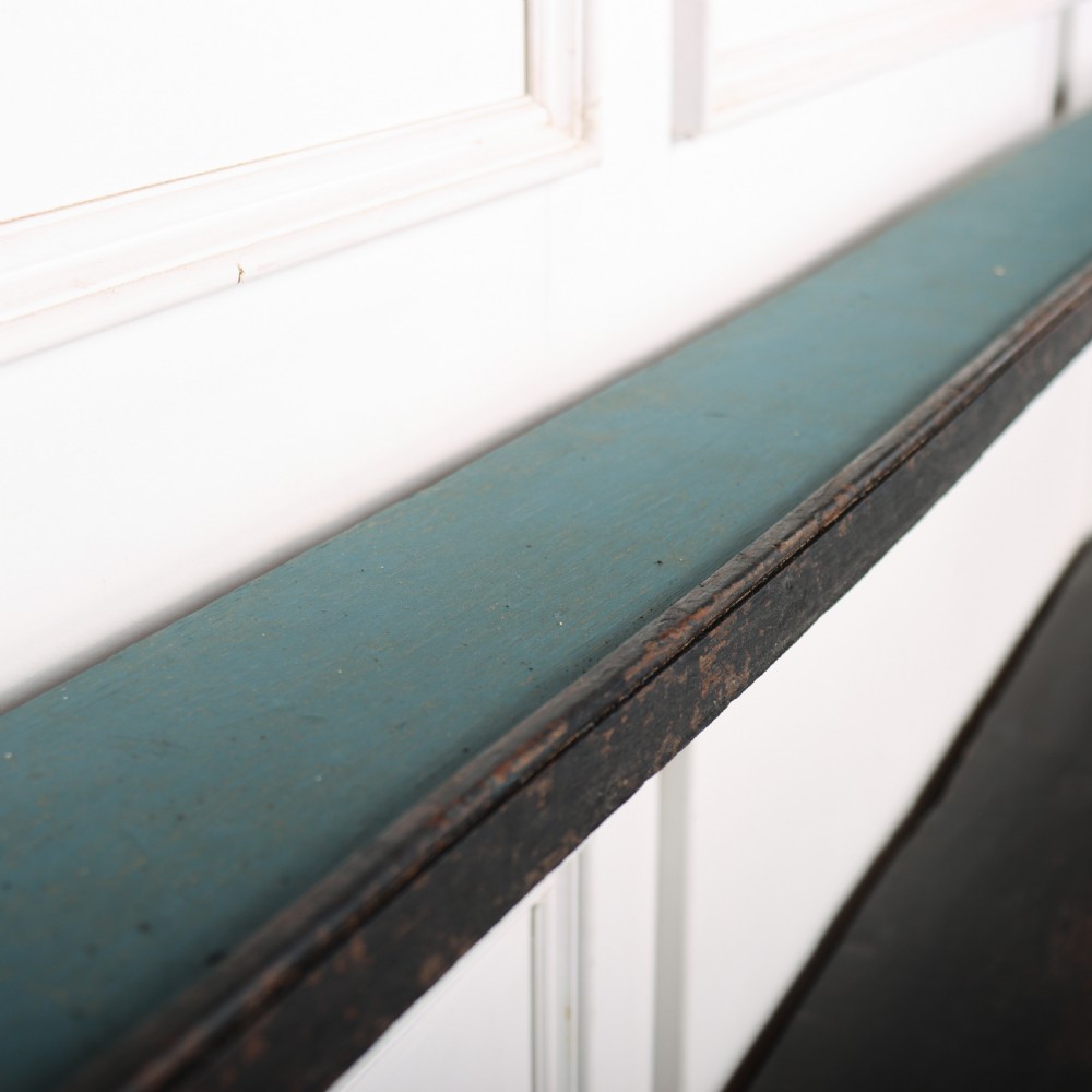 An 18th-century dark painted wooden kitchen dresser base featuring four drawers with brass handles beneath an open wall-mounted plate rack. View X