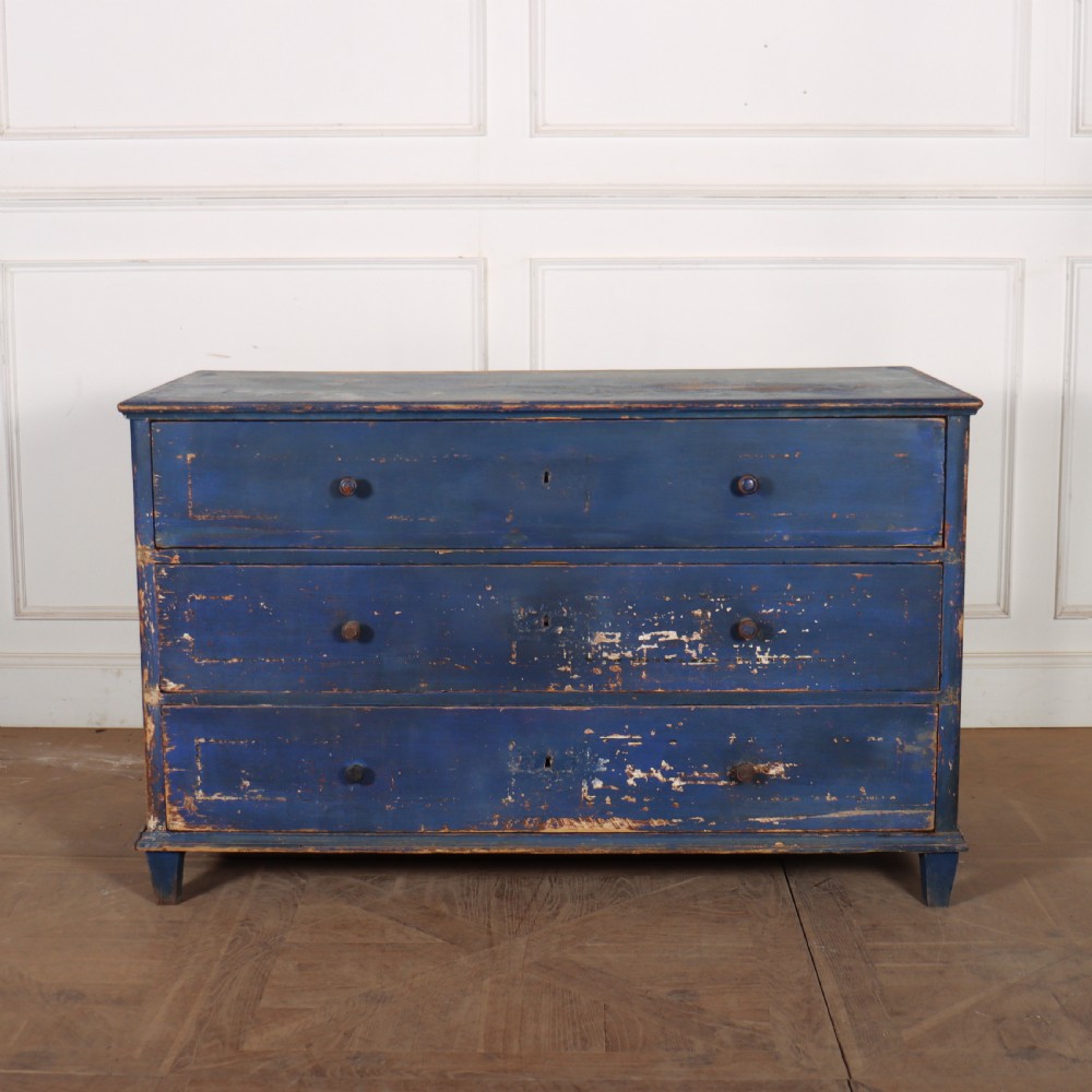 A three-drawer wooden chest of drawers featuring a weathered blue painted finish, small turned knobs, and square tapered feet.
