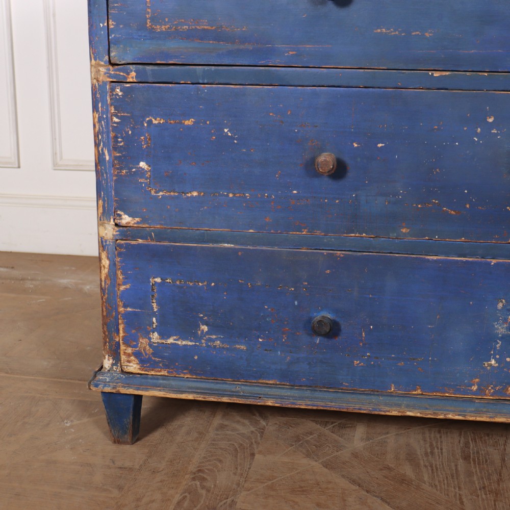 A three-drawer wooden chest of drawers featuring a weathered blue painted finish, small turned knobs, and square tapered feet. View V